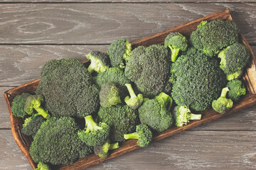 inflorescences of fresh ripe broccoli on a wooden tray top view. ripe fresh broccoli close-up. harvest broccoli and copy space
