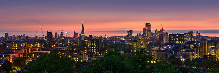 Londons Skyline in der blauen Stunde. Die Lichter und die intensiven Farben des Abendrots verleihen dem Panorama eine magische Stimmung.