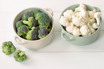 fresh broccoli and cauliflower in bowls on a white background close-up. fresh vegetables on the table.