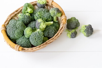 fresh broccoli in a wicker basket on a white background close-up. background with a broccoli harvest in a basket.