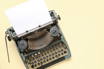 Fototapeta na wymiar Vintage typewriter with blank paper sheet on yellow background