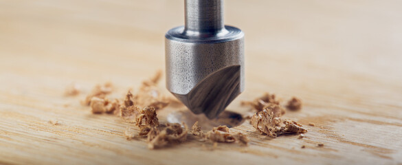 Countersink drill bit with steel triangle ruler make sink in hole for screw in wooden oak plank