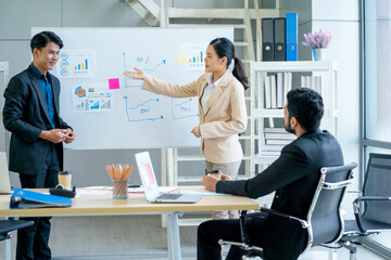 Asian business man and woman stand in front board to present the project for manager in office with day light.