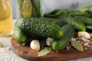 Wooden board with fresh cucumbers for preservation on table, closeup
