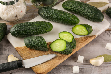 Board with fresh cut cucumbers for preservation on table