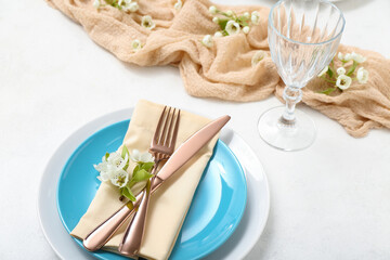 Beautiful table setting with blooming tree branches on white background