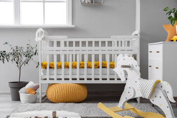 Baby crib in interior of light bedroom