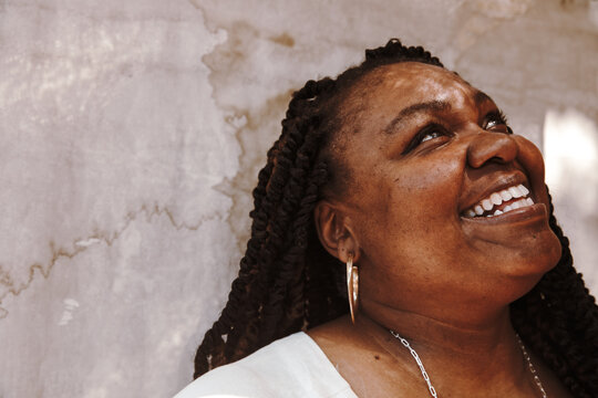 portrait of a plus size Afro Latinx Haitian American woman smiling and looking up