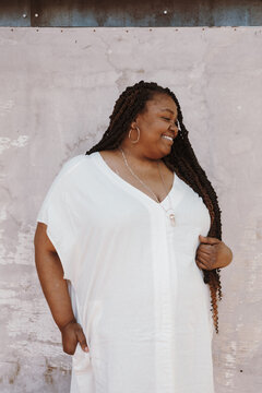 portrait of a plus size afro latinx haitian american woman wearing white looking away