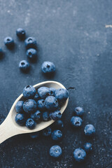 Fresh blueberry on wooden spoon. Flat lay, top view
