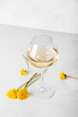 Glass of dandelion wine on white table