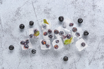 Fresh blueberry frozen in ice cubes on grunge background