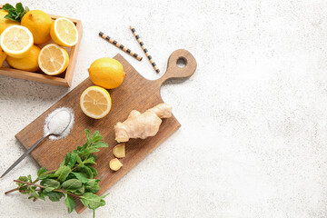 Wooden board and box with ingredients for preparing lemonade on grunge white background