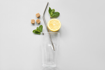 Glass with lemons and mint on grey background