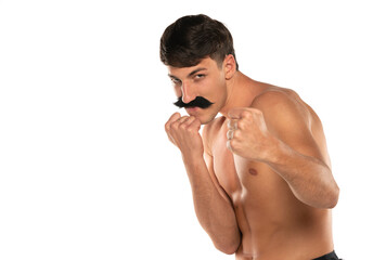 Young shirtless man with moustache in boxing stance on a white background
