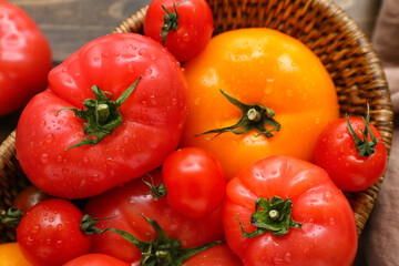 Wicker bowl with different fresh tomatoes, closeup