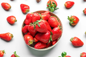 Bowl of fresh strawberries on white background