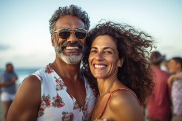 Middle age cuddling couple enjoying time on beach
