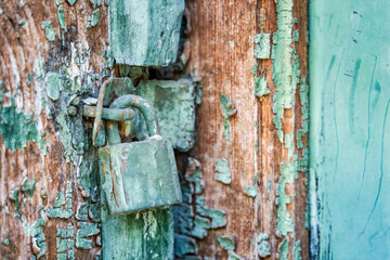 Old rusted padlock on a blue wooden door