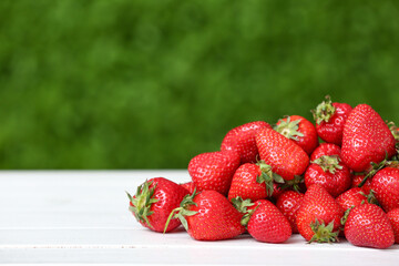 Heap of fresh strawberry on white table outdoors