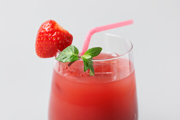 Glass of tasty strawberry juice on grey background