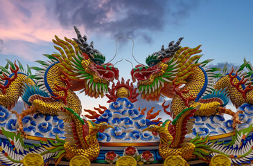 Fototapeta na wymiar Colourful multicoloured dragon on top of a temple in Patong Phuket Thailand. beautiful blue green red of the scale dragons