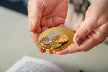 A Jewish woman performs pre-wedding rituals with silver shekels for a secure life.