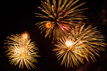 Golden sparks of fireworks bright shining on the black night sky.