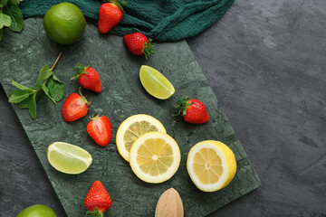 Ripe strawberry, lime, lemon and mint on dark background