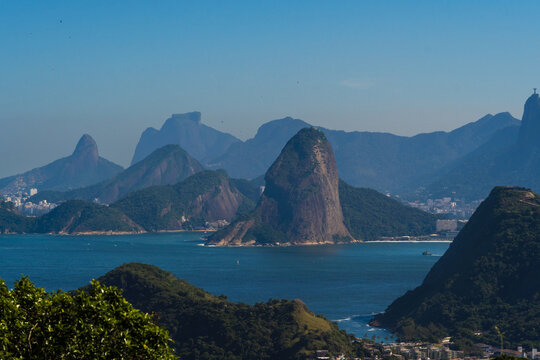 Beautiful view of Rio de Janeiro, Brazil seen from Niterói. With many hills in the background, Guanabara Bay, Jujuruba, Sugarloaf Mountain, Christ the Redeemer, beaches, pier with boats. Sunny day