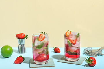 Glasses of delicious strawberry mojito on color background