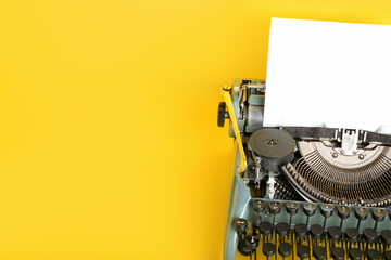 Vintage typewriter on yellow background