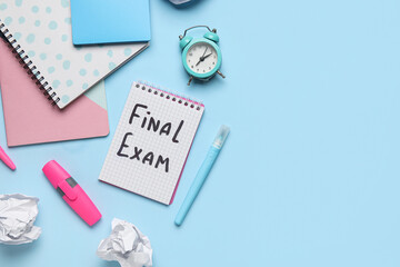Notebooks with text FINAL EXAM, different stationery and alarm clock on blue background
