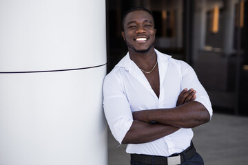 portrait of happy african man near building	