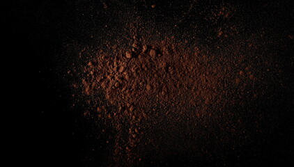 Cocoa powder pile isolated on black background, top view