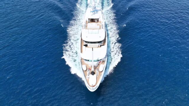 Aerial drone video of luxury yacht with wooden deck cruising open ocean deep blue Aegean sea