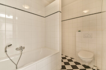 a white bathroom with black and white checkered tiles on the floor, along with a toilet in the corner