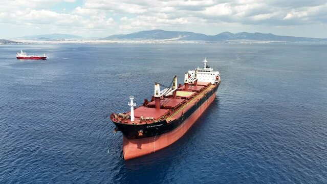 Aerial drone video of huge bulk carrier tanker anchored in deep blue Aegean sea