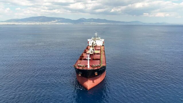 Aerial drone video of huge bulk carrier tanker anchored in deep blue Aegean sea
