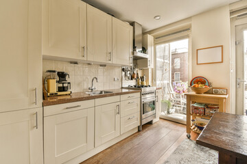 a kitchen with all white cabinets and wood counter tops on the floor in front of the door to the...