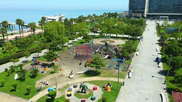 aerial photography of drones in park of Batumi Boulevard Lekha and Maria Kaczynski. This park has many facilities for children, as well as children's playground by sea on sunny day. View city Batumi
