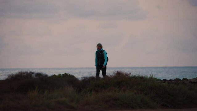 Solo female walking outdoors desert ocean coastal path 