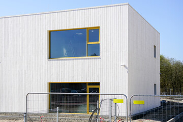 Construction site of a new nursery school building, facade fragment, temporary portable metal fence