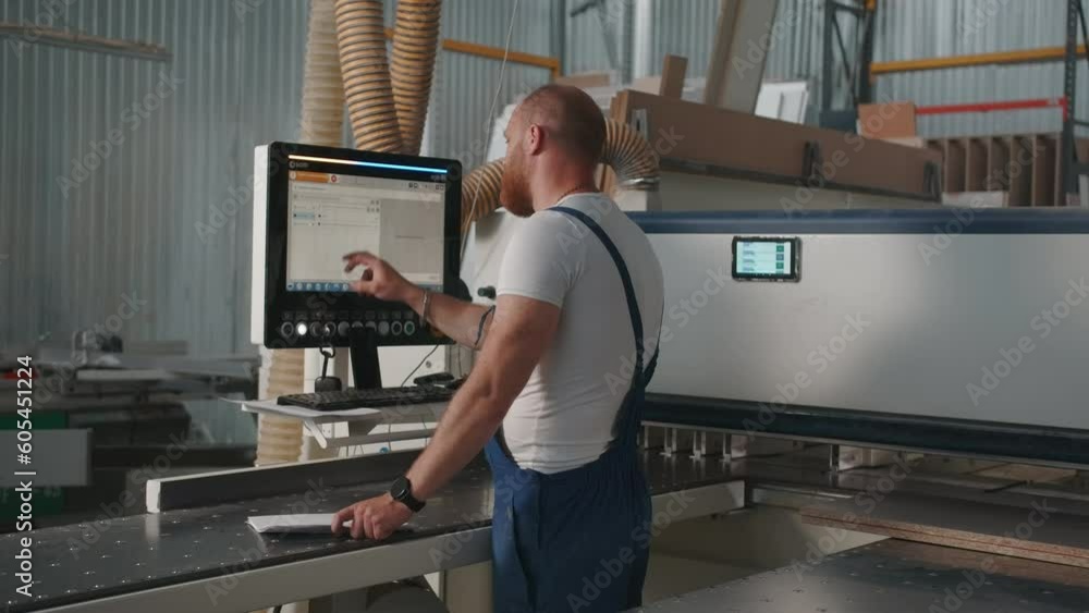 Poster man clicks on control panel. creative. man with beard in work uniform at factory. man adjusts contro