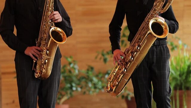 ensemble in black suits playing saxophones