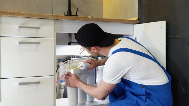 Plumber installs or change water filter. Replacement aqua filter