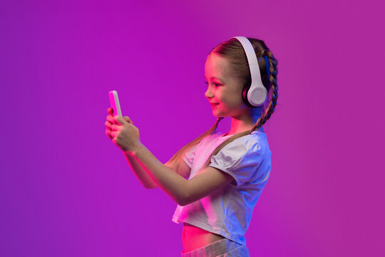 Happy girl have video call with friends, using headphones, phone