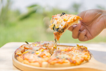Woman picking up hot pizza