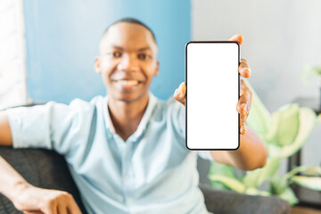 smiling man showing mobile phone blank white screen mockup to camera.
