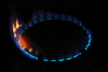 The blue flame of a burning gas stove in a kitchen 